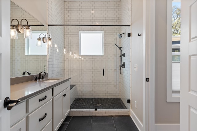 bathroom featuring vanity, a healthy amount of sunlight, tile patterned flooring, and a shower with door