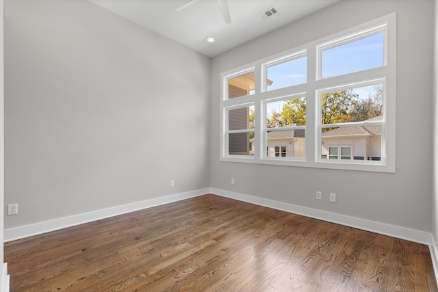 unfurnished room featuring a wealth of natural light, hardwood / wood-style flooring, and ceiling fan