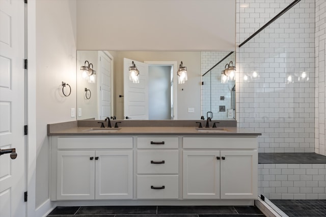 bathroom featuring vanity, tiled shower, and tile patterned flooring