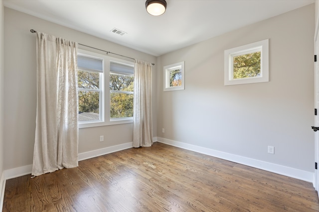 unfurnished room with hardwood / wood-style flooring and a wealth of natural light