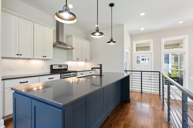 kitchen featuring wall chimney exhaust hood, dark wood-type flooring, sink, stainless steel range with gas cooktop, and white cabinets