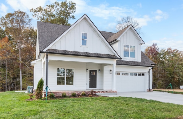 view of front of house with a garage, a front yard, and covered porch