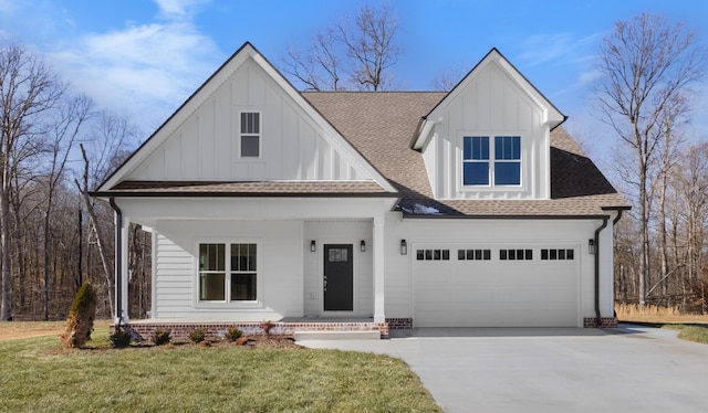 view of front of property with a garage, covered porch, and a front lawn