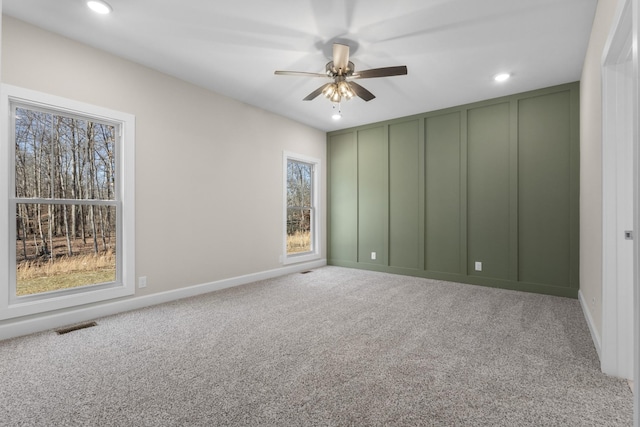 carpeted spare room with ceiling fan