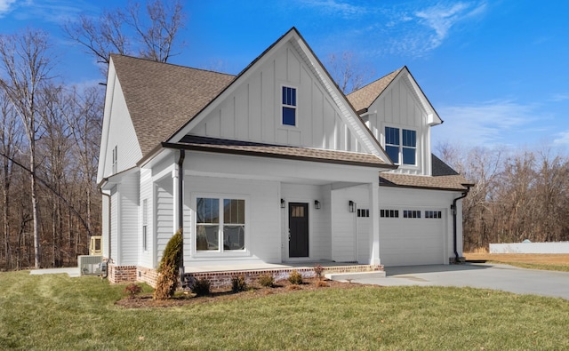 view of front of property with a garage, a front lawn, and covered porch