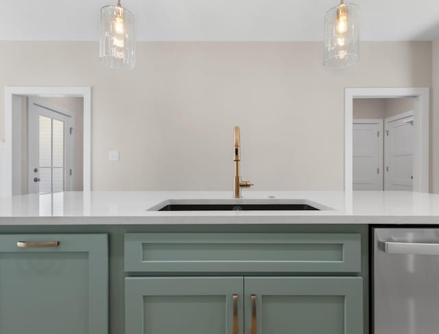 kitchen featuring pendant lighting, sink, green cabinetry, and dishwasher