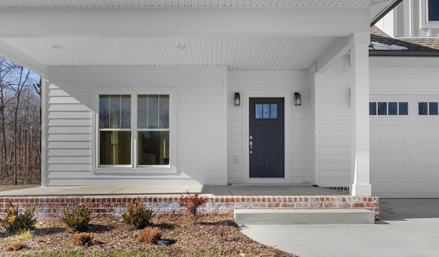 entrance to property with a garage and a porch