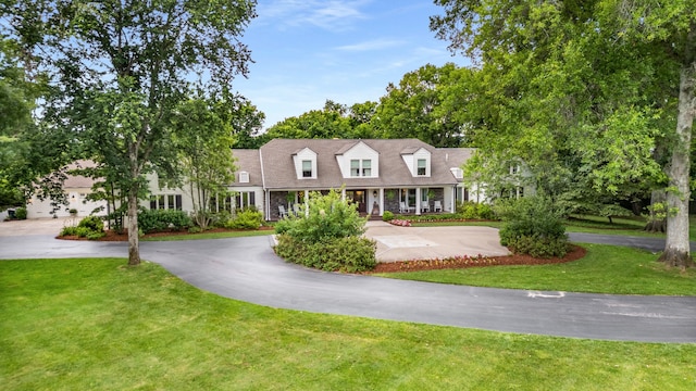 cape cod house featuring a front yard