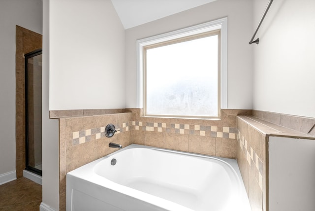 bathroom featuring a healthy amount of sunlight, tile patterned floors, separate shower and tub, and vaulted ceiling