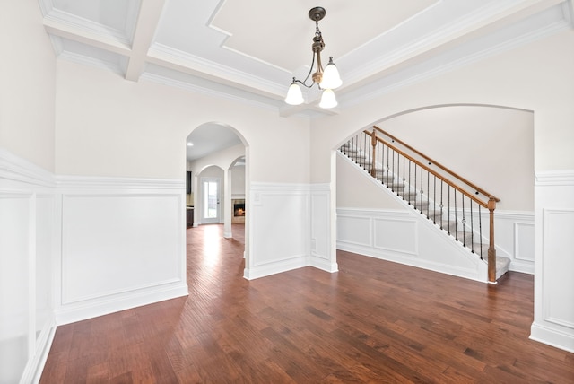 interior space featuring ornamental molding, dark wood-type flooring, and a notable chandelier