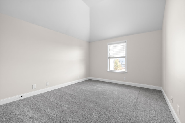 unfurnished room with carpet and vaulted ceiling