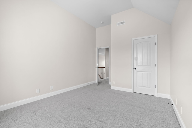 unfurnished bedroom featuring lofted ceiling and carpet