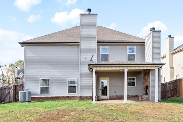 rear view of house featuring a lawn, central AC, and a patio area