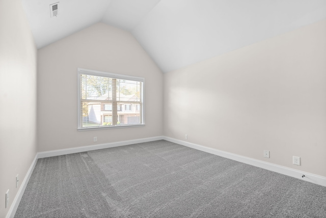 empty room featuring lofted ceiling and carpet