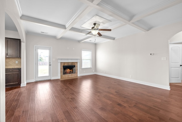 unfurnished living room featuring dark hardwood / wood-style flooring, coffered ceiling, ornamental molding, beamed ceiling, and ceiling fan