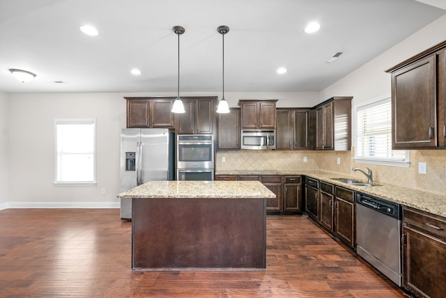 kitchen featuring stainless steel appliances, dark wood-type flooring, pendant lighting, and a kitchen island