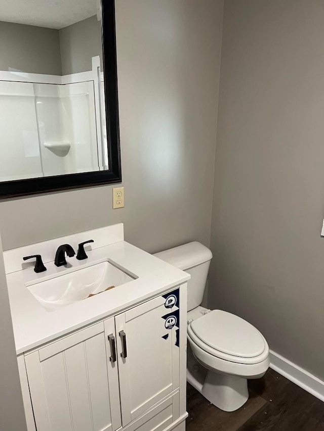 bathroom featuring vanity, wood-type flooring, and toilet