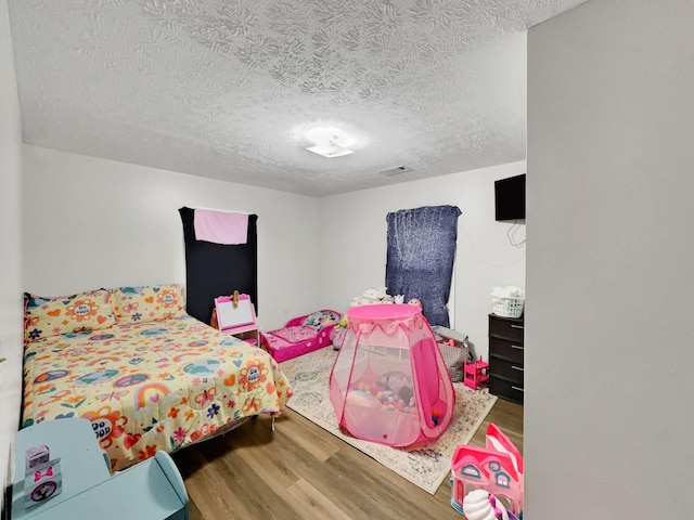 bedroom with wood-type flooring and a textured ceiling