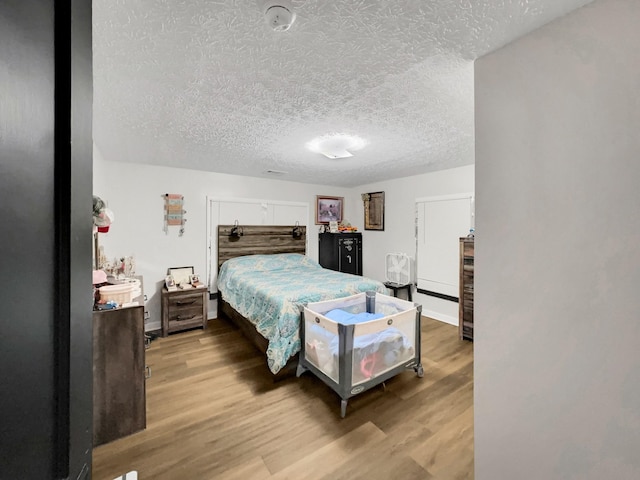 bedroom with hardwood / wood-style flooring and a textured ceiling