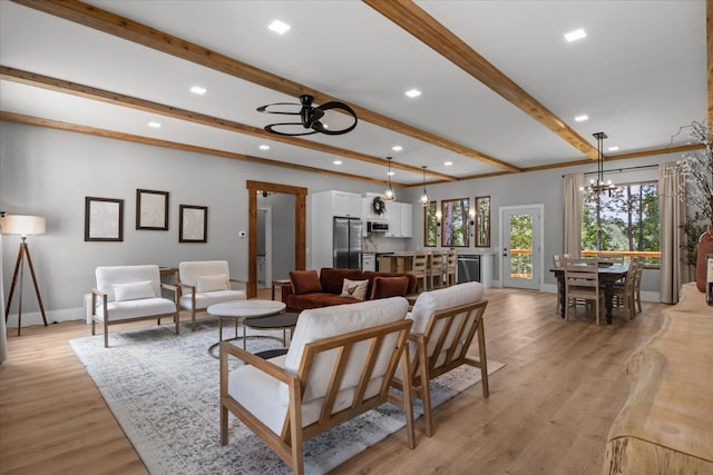 living room featuring light hardwood / wood-style flooring, beam ceiling, and ceiling fan with notable chandelier