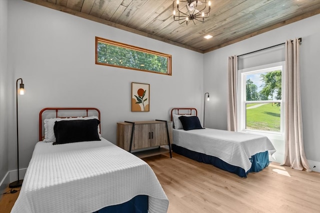 bedroom with a chandelier, light hardwood / wood-style flooring, and wooden ceiling