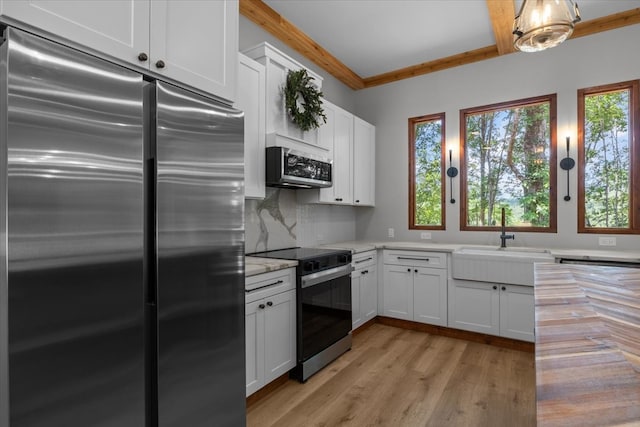 kitchen featuring white cabinetry, a healthy amount of sunlight, appliances with stainless steel finishes, and sink