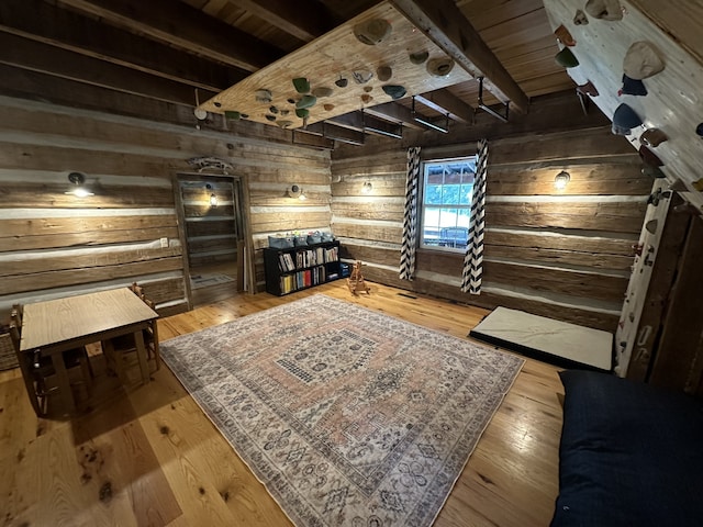 sitting room featuring hardwood / wood-style floors, beamed ceiling, and wooden walls