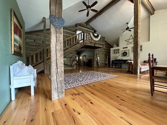 interior space featuring beam ceiling, high vaulted ceiling, wood-type flooring, and ceiling fan