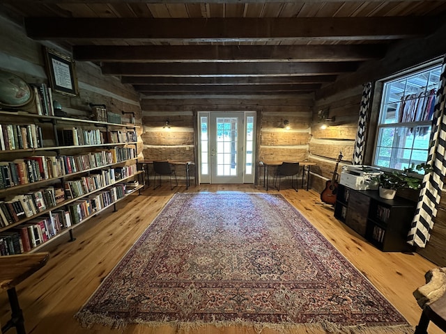 living area with wood ceiling, wood walls, beamed ceiling, and hardwood / wood-style floors