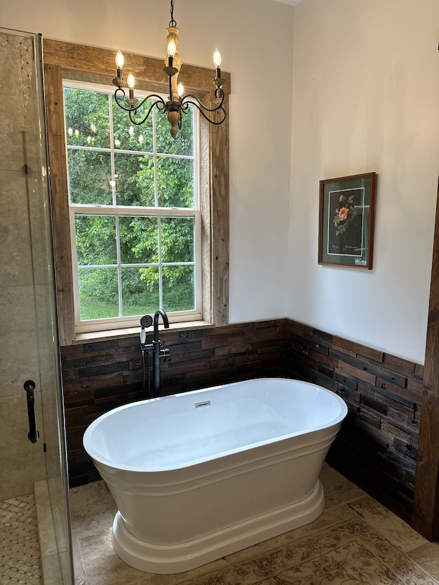 bathroom with a notable chandelier, tile walls, tile patterned flooring, and plus walk in shower