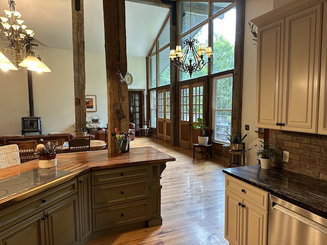 kitchen featuring stainless steel dishwasher, a notable chandelier, cream cabinetry, and light hardwood / wood-style floors