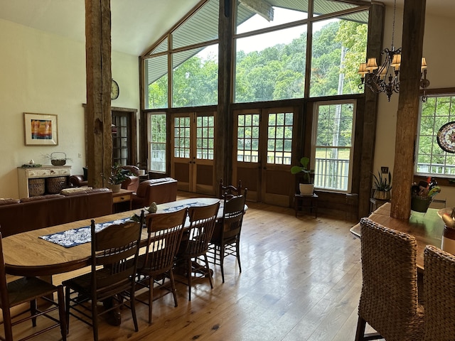 dining area with an inviting chandelier, lofted ceiling, light wood-type flooring, and plenty of natural light