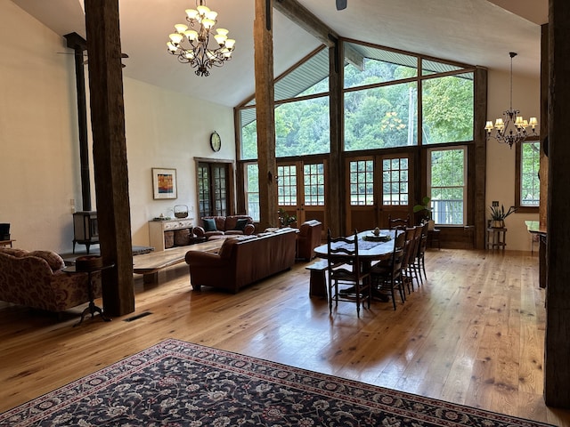 dining space with a notable chandelier, light wood-type flooring, and a wood stove