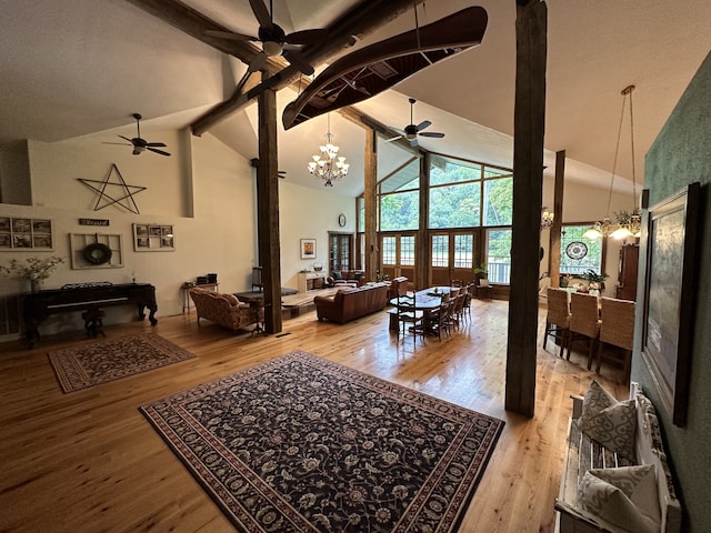 living room featuring light hardwood / wood-style flooring, a notable chandelier, and high vaulted ceiling