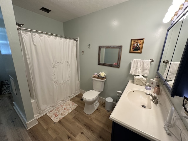 full bathroom with a textured ceiling, hardwood / wood-style floors, toilet, vanity, and shower / bathtub combination with curtain