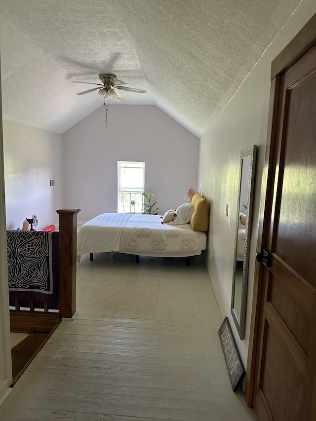 bedroom with lofted ceiling, a textured ceiling, light hardwood / wood-style floors, and ceiling fan