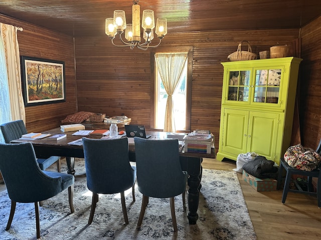 dining room with hardwood / wood-style floors, a chandelier, and wood walls