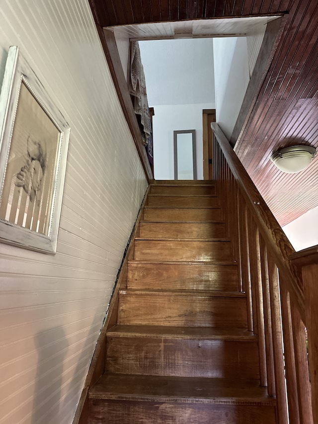 stairs featuring wood walls