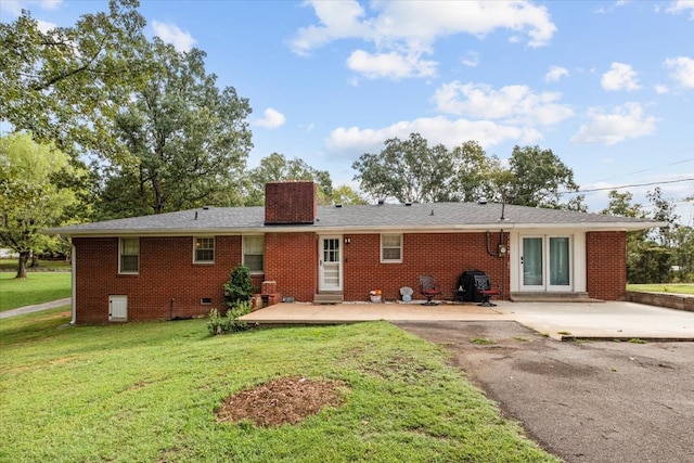 back of house with a lawn and a patio