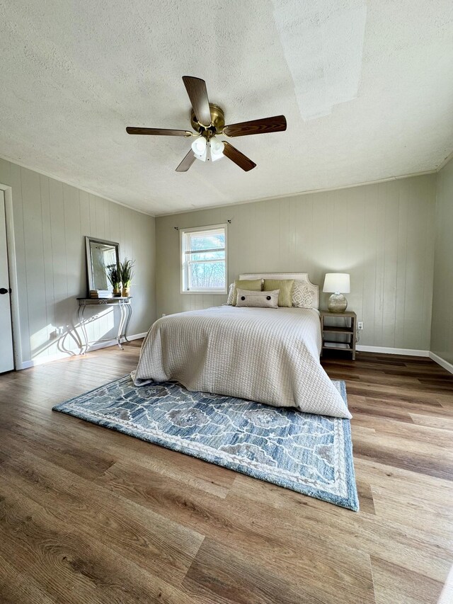 bedroom featuring a textured ceiling, ceiling fan, and hardwood / wood-style floors