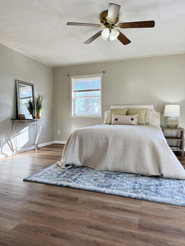 bedroom with a textured ceiling, ceiling fan, and dark hardwood / wood-style floors