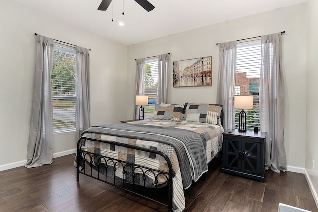 bedroom featuring multiple windows, dark hardwood / wood-style floors, and ceiling fan