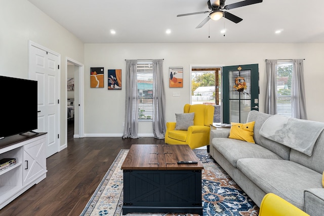 living room with ceiling fan, a wealth of natural light, and dark hardwood / wood-style flooring