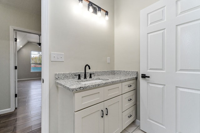 bathroom featuring vanity, lofted ceiling, wood-type flooring, and ceiling fan