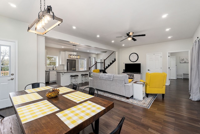 dining space with sink, ceiling fan, a healthy amount of sunlight, and dark hardwood / wood-style flooring