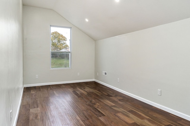 additional living space with dark wood-type flooring and vaulted ceiling