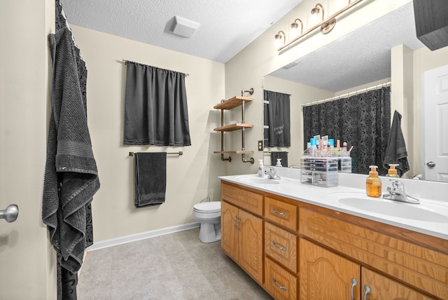 bathroom with curtained shower, vanity, a textured ceiling, and toilet