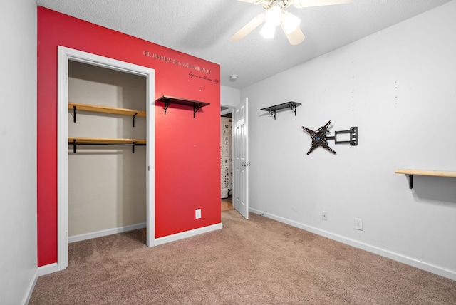 unfurnished bedroom with carpet flooring, ceiling fan, a closet, and a textured ceiling