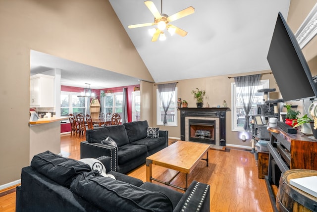 living room featuring ceiling fan, light hardwood / wood-style flooring, and high vaulted ceiling