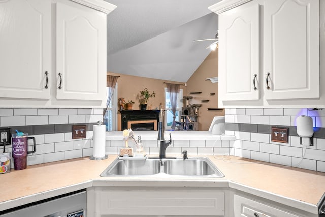 kitchen featuring a textured ceiling, white cabinetry, sink, and tasteful backsplash